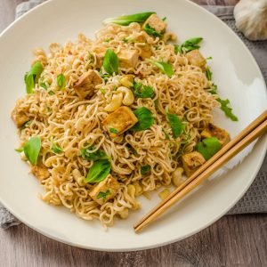 Chinese noodles with tofu and cashew nuts, with garlic, fresh salad on top