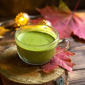 green-japanese-matcha-tea-with-foam-in-transparent-cup-on-wooden-table-in-autumn.jpg